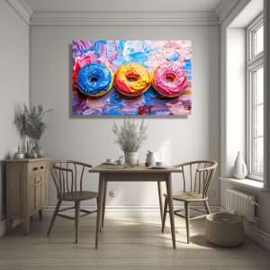 Cuadro decorativo con tres donuts de colores sobre fondo abstracto.