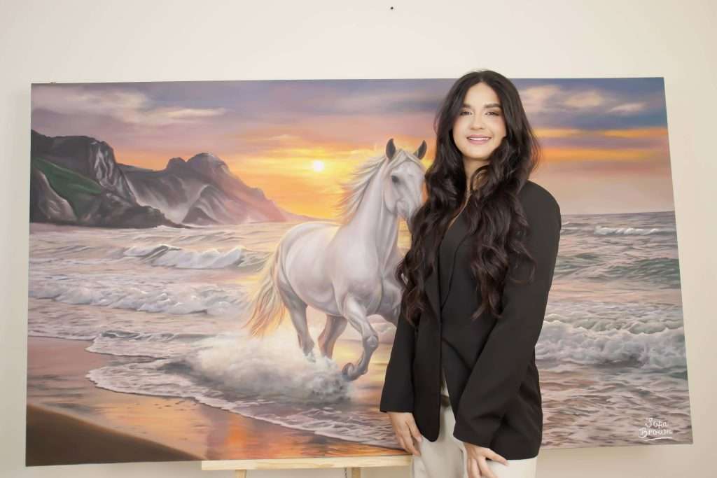 Sofia Brown artista colombiana junto a su obra completa de caballo al oleo espatulado