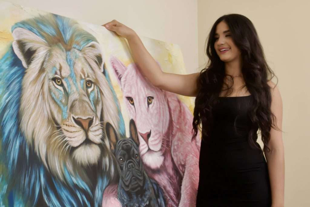 Sofia Brown artista colombiana con cuadro de familia de leones pintado al oleo